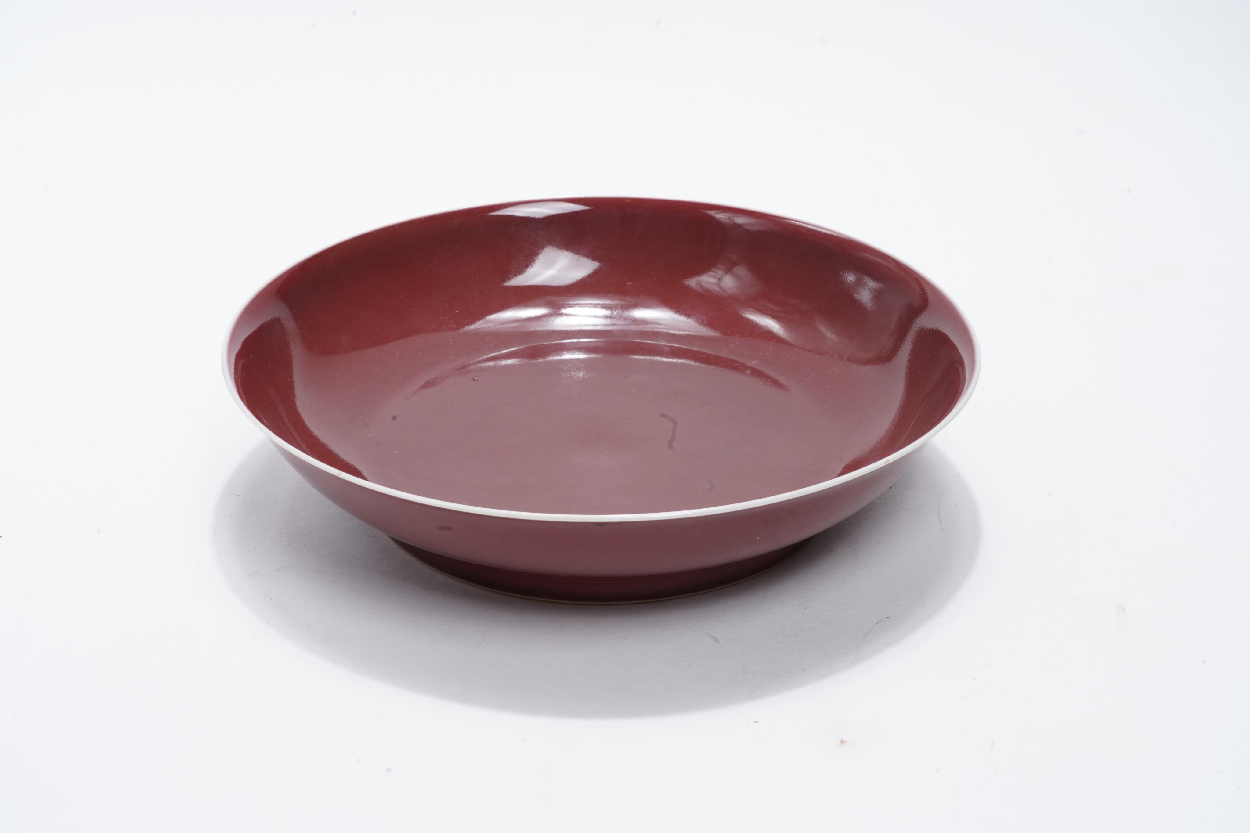 A Chinese copper-red glazed saucer dish, Qianlong six-character seal mark and of the period (1736-95)